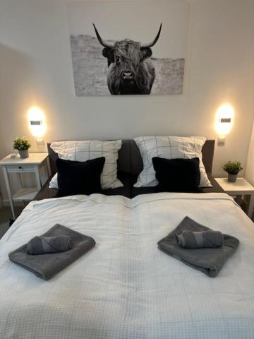 Una cama con dos almohadas y una cabeza de toro. en Ferienwohnung Domspatz mit Klimaanlage, en Magdeburgo