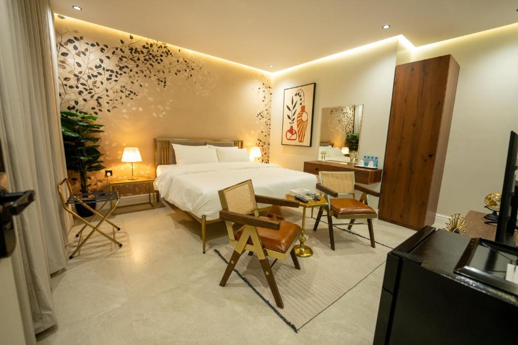 شقق درر السكنية تصميم إيطالي مريح في قلب الرياض دخـول ذاتي في الرياض: غرفة نوم بسرير وطاولة وكراسي