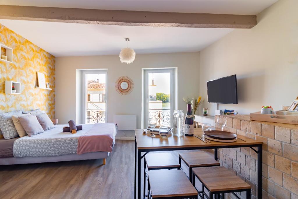 Cet appartement comprend une chambre avec un lit et une table ainsi qu&#39;une cuisine. dans l&#39;établissement AU PIED Du Grand Bassin, à Castelnaudary