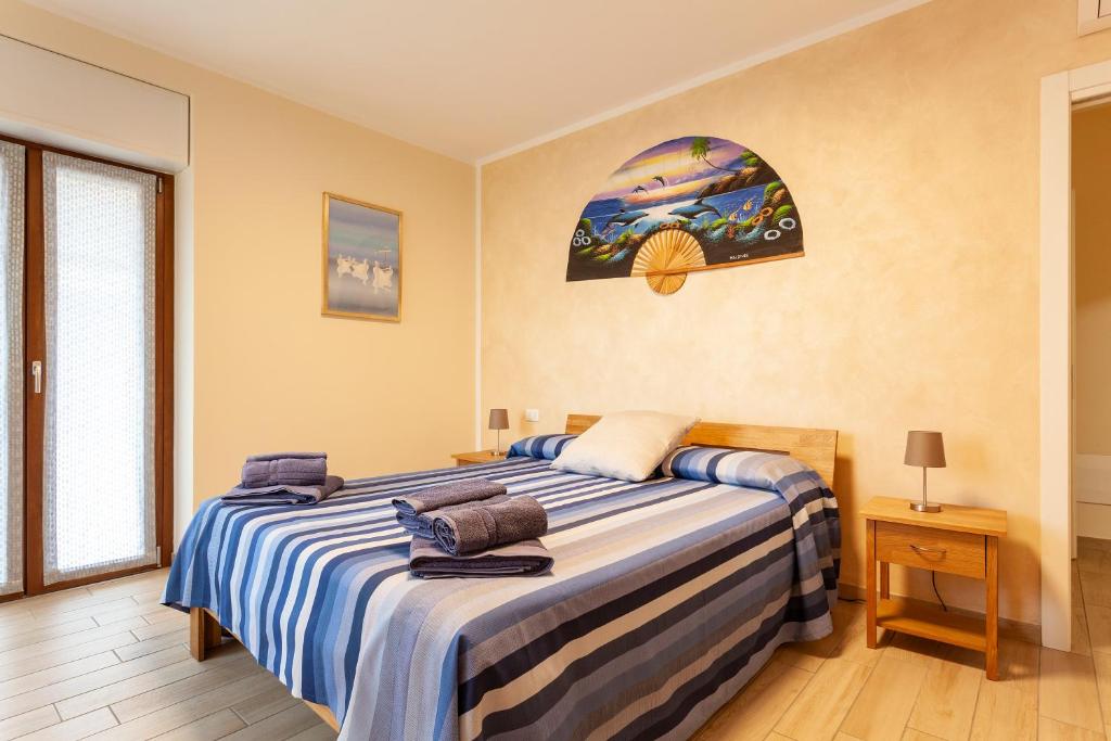 a bedroom with a large bed with blue and white sheets at Veruskacamere Camera 1 in Somma Lombardo