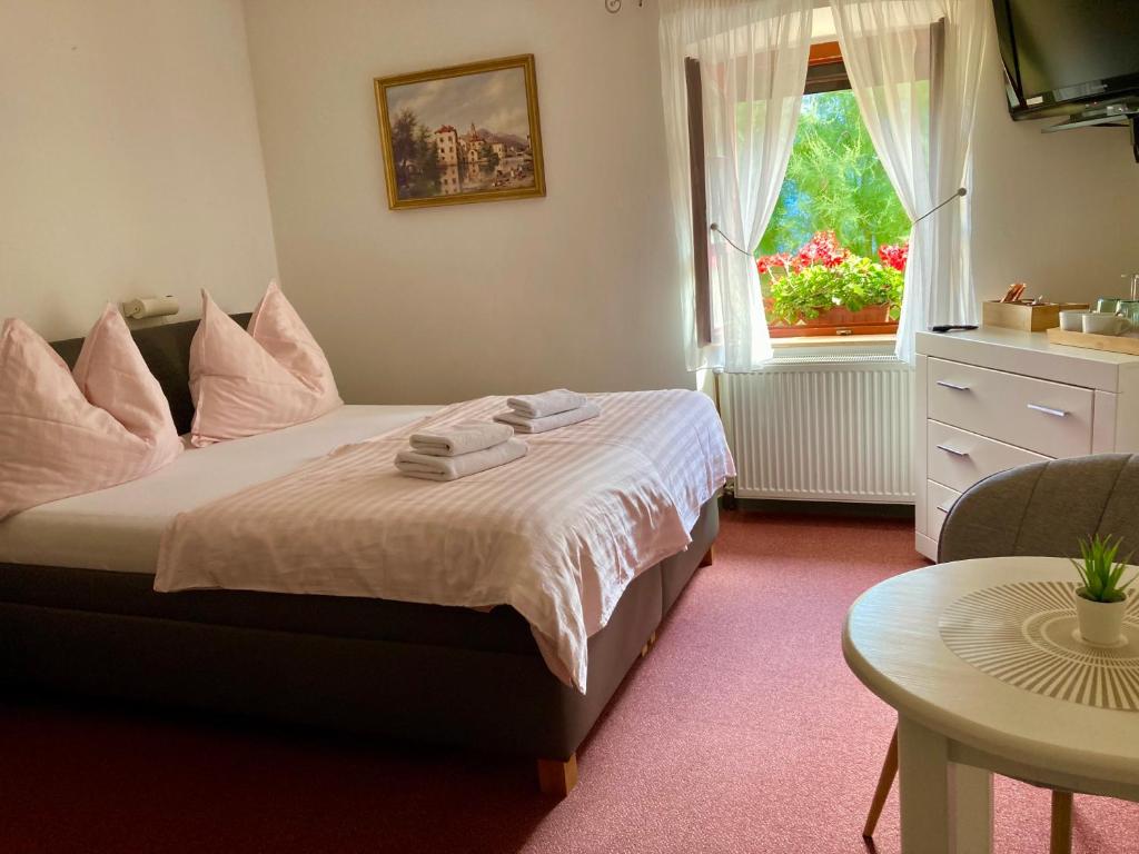 a bedroom with a bed with a window and a table at Guesthouse Mikuláš Mikulov - free parking in the city center in Mikulov
