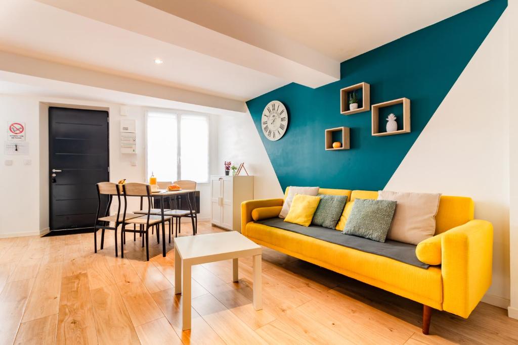 - un salon avec un canapé jaune et une table dans l'établissement LE CAPITAINE Port De Castelnaudary Avec Box, à Castelnaudary
