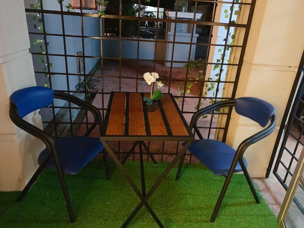 une table et des chaises avec une fleur dans un vase sur un balcon dans l'établissement SSR 41 SEREMBAN TOWN 4R3B homestay, à Seremban