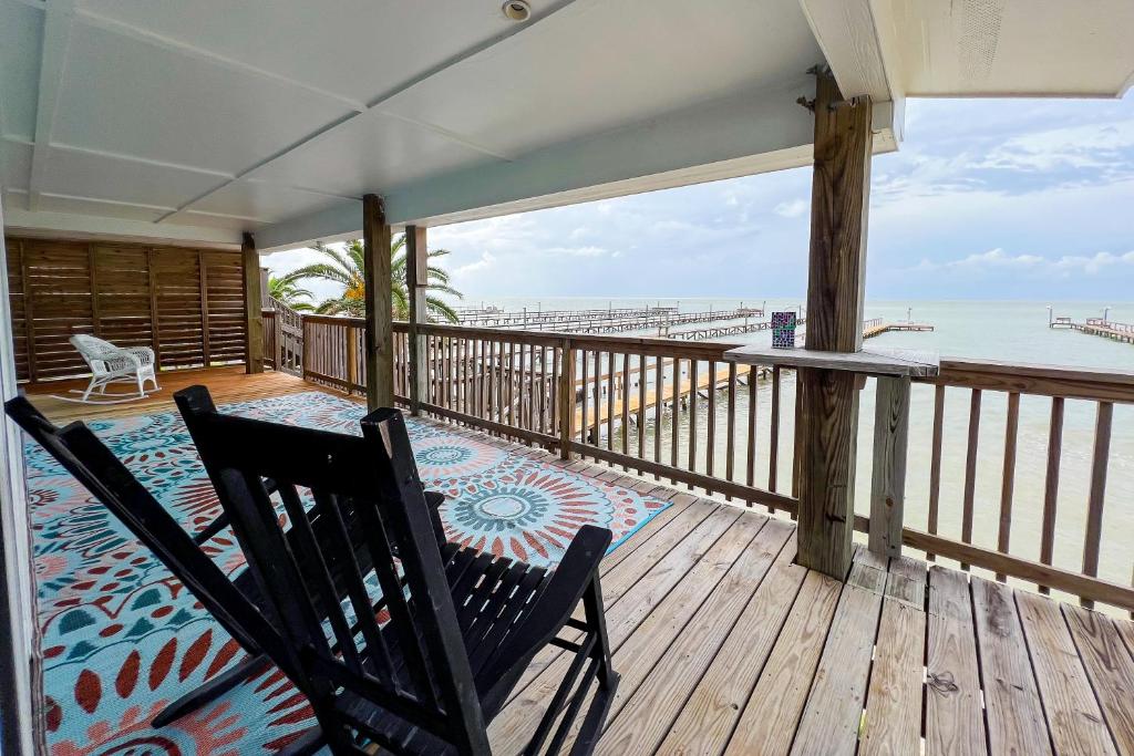 a deck with two chairs and a view of the beach at Bayalicious in Rockport