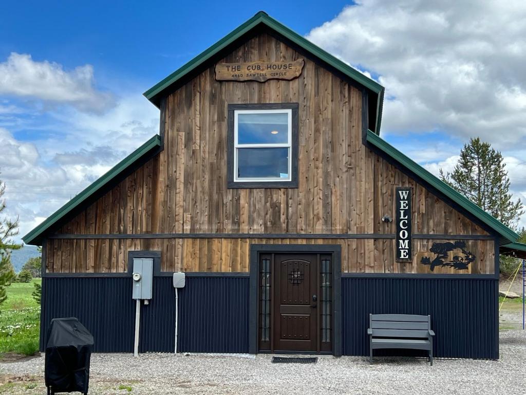 een grote houten schuur met een deur en een raam bij Escape to A Luxe Mountain Barn Home Retreat w Gourmet Kitchen 3 beds, 2 and Half Baths near YNP! in Rea