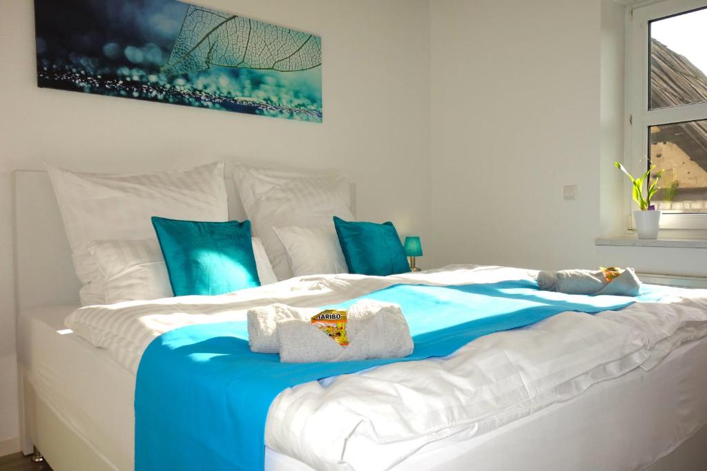 uma cama com lençóis e toalhas azuis e brancas em HAPPY HOMES - Up to 5 - Küche - W-LAN - Netflix - Honig - Balkon em Nidda