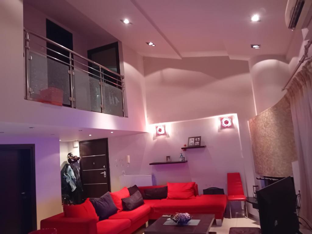 ein Wohnzimmer mit einem roten Sofa und einem TV in der Unterkunft ΜΕΖΟΝΈΤΑ in Síndos