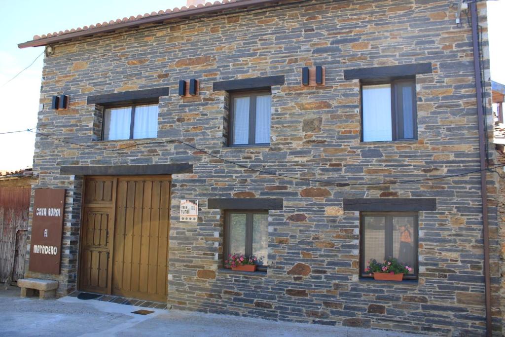 um edifício de tijolos com três janelas e uma garagem em Casa Rural El Mayadero em Zamora