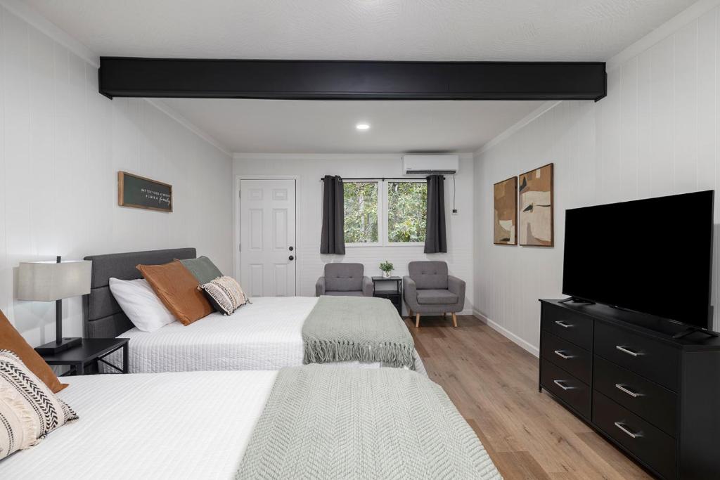 a bedroom with two beds and a flat screen tv at The Lofts on Indian Point - Near Silver Dollar City in Branson