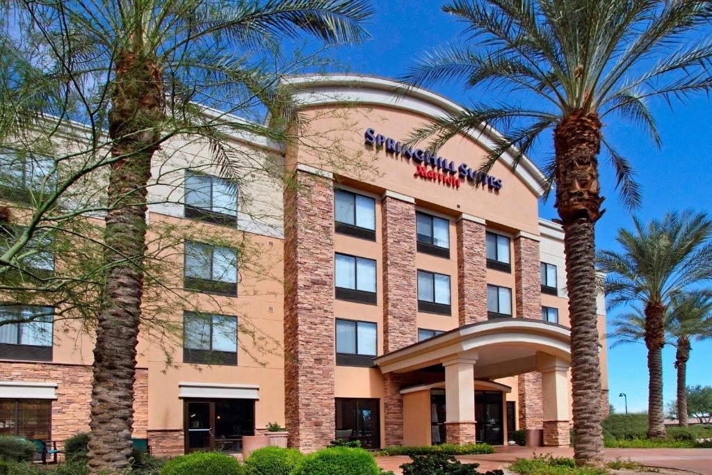 a hotel with palm trees in front of it at SpringHill Suites Phoenix Glendale Sports & Entertainment District in Glendale