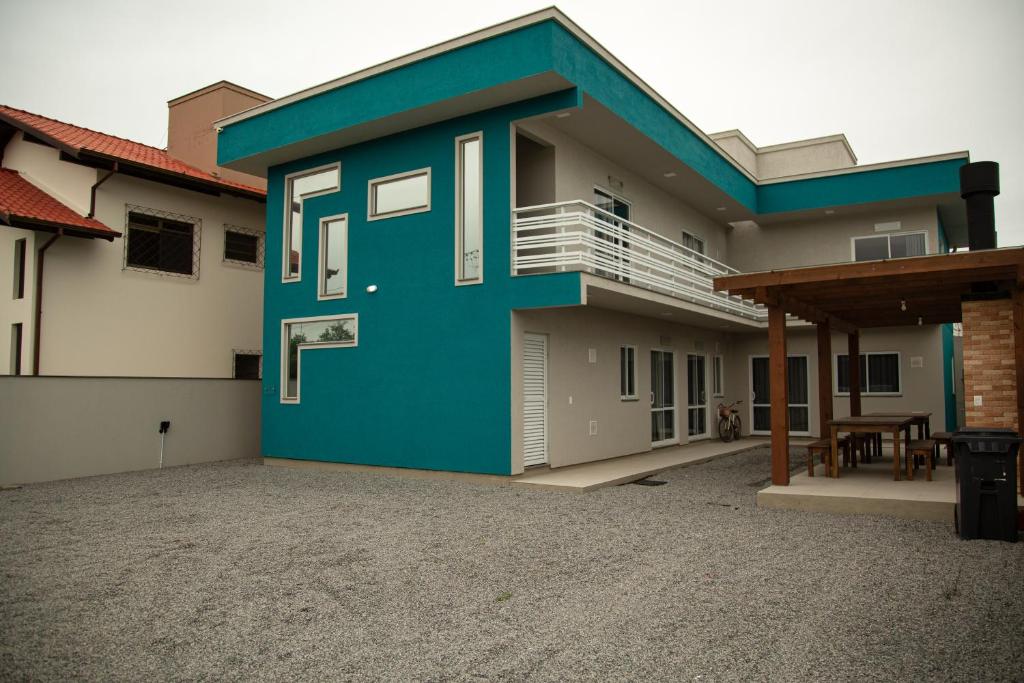 un edificio azul con balcón en una entrada de entrada en 1- MAHALO - Aloha Bratz Apartments en Palhoça
