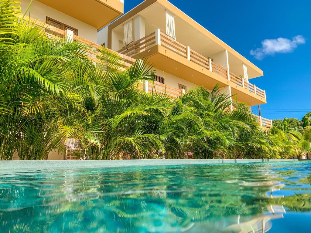 a resort with a swimming pool in front of a building at Isla penthouse & garden apartments Bonaire in Kralendijk