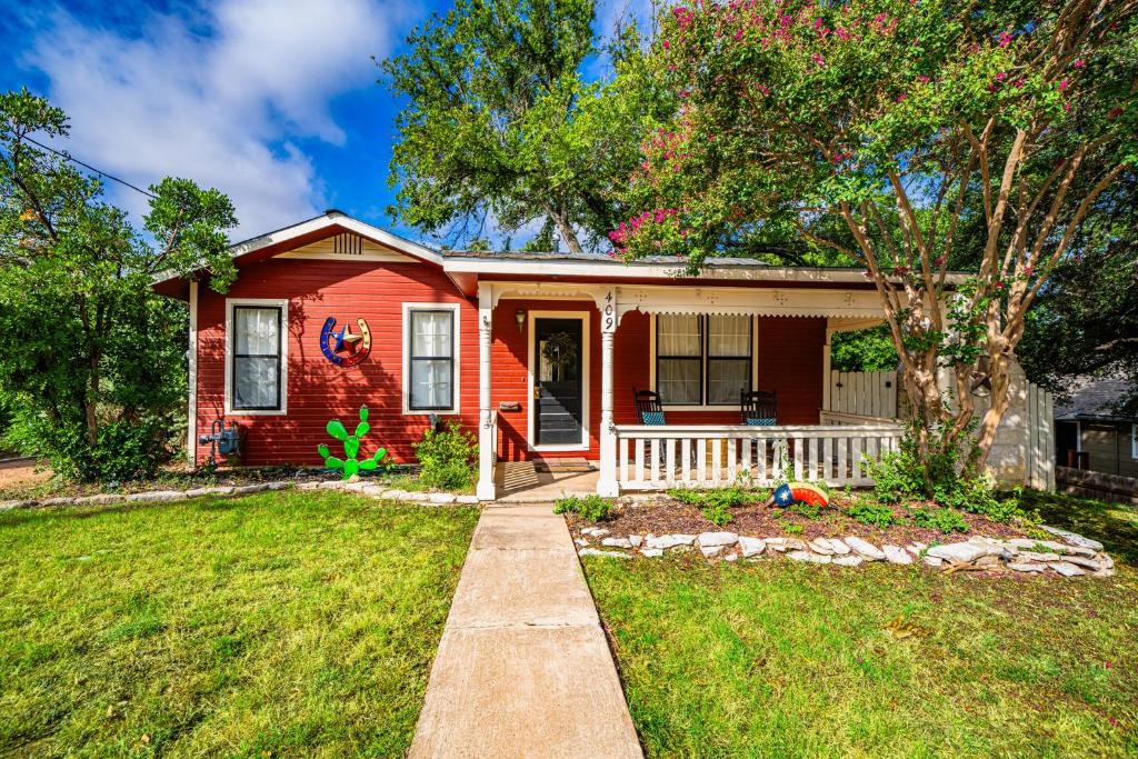 a red house with a pathway leading to the front door at Ava and Weston Combo House in Fredericksburg