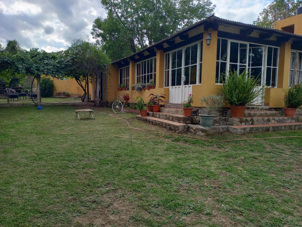 una casa con un patio con una manguera de jardín en La Chona en Vaqueros