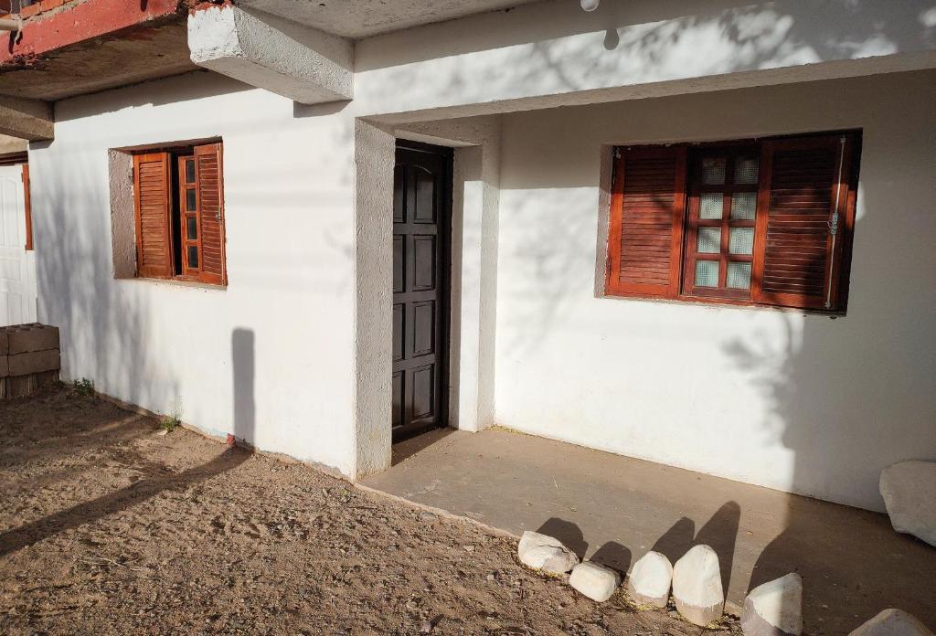 una casa con dos ventanas y algunas sandalias en el suelo en Casa Uziel en Humahuaca