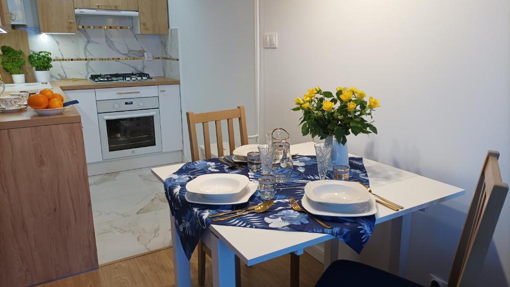 une cuisine avec une table et un vase de fleurs. dans l'établissement Apartament Sztygara, à Mikołów