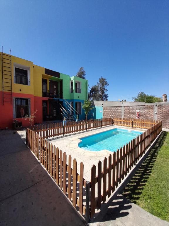 a swimming pool with a wooden fence around it at Complejo Don Tito in San Juan