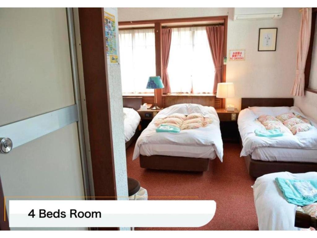 una camera con tre letti e una camera con una camera da letto di Hotel Montblanc Hakuba - Vacation STAY 49692v a Hakuba