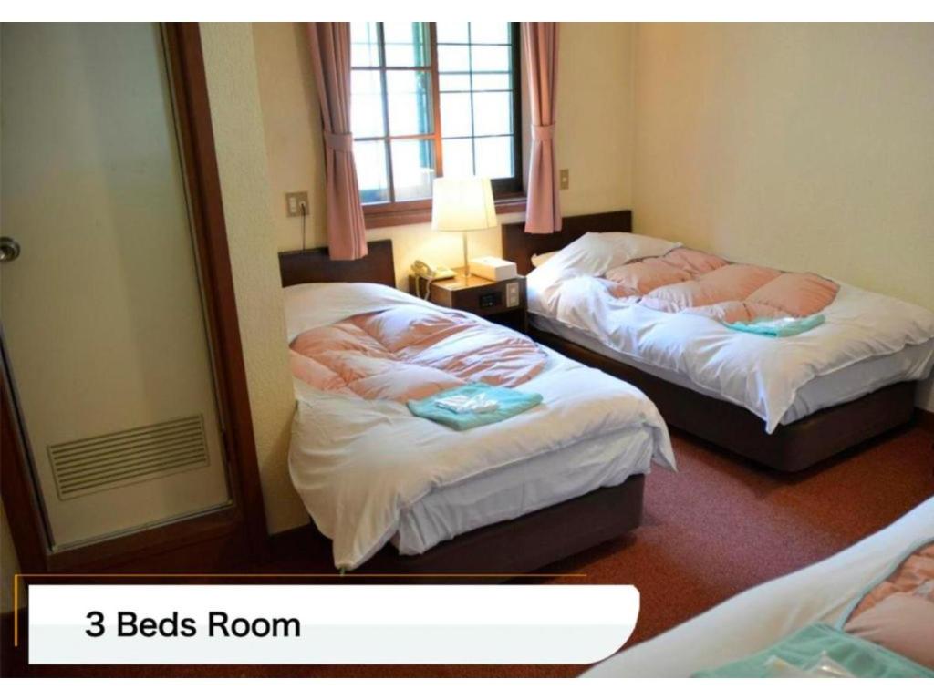 two beds in a hotel room with two bedsoren at Hotel Montblanc Hakuba - Vacation STAY 49687v in Hakuba