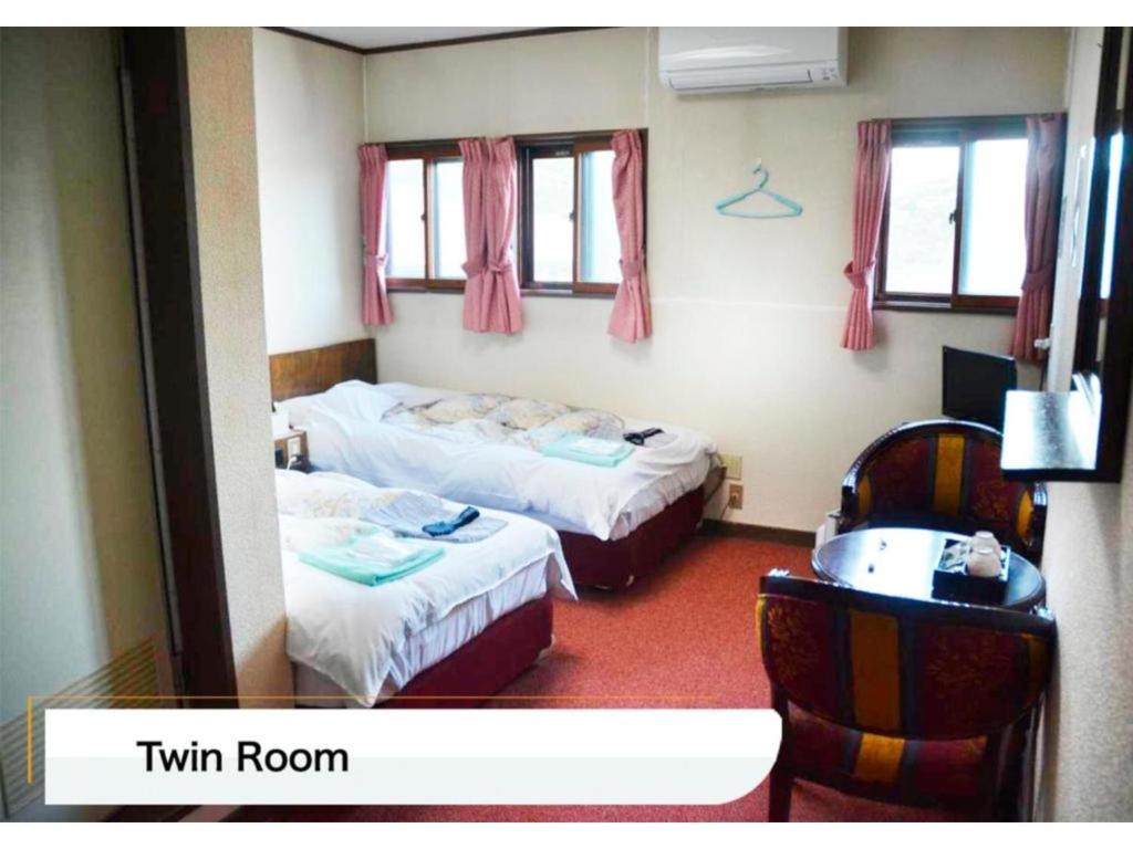 una camera d'albergo con due letti e un lavandino di Hotel Montblanc Hakuba - Vacation STAY 49679v a Hakuba