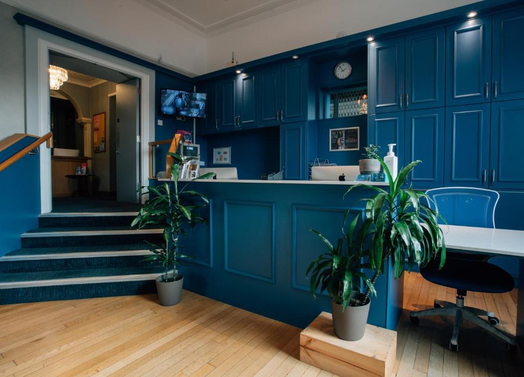 a blue kitchen with potted plants and a staircase at Manor Hotel in Exmouth