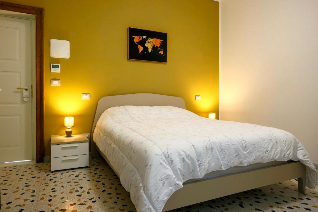 una camera con un letto bianco e una parete gialla di Al Castello Avezzano ad Avezzano
