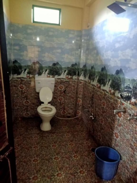 a bathroom with a toilet and a painting on the wall at Shri gopal marble farm house in Bhopal