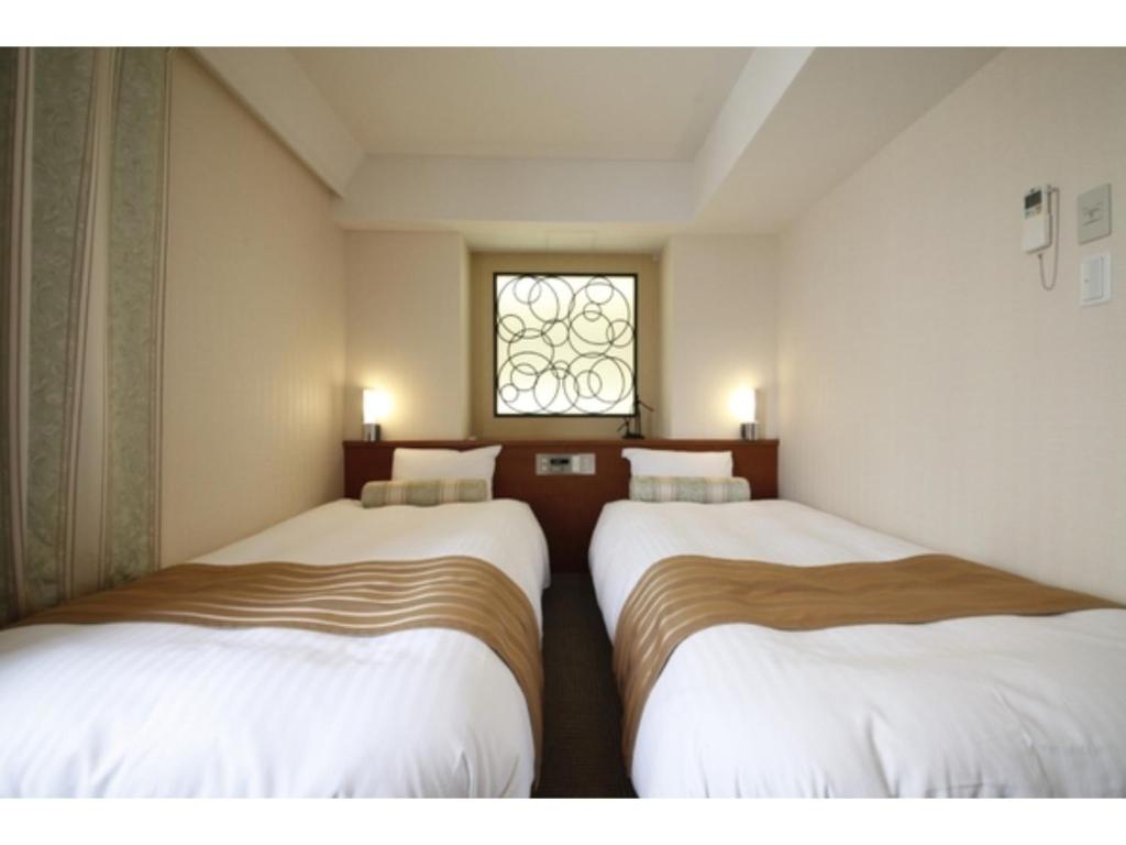 2 camas en una habitación pequeña con ventana en Hotel Shinjukuya - Vacation STAY 74754v en Machida