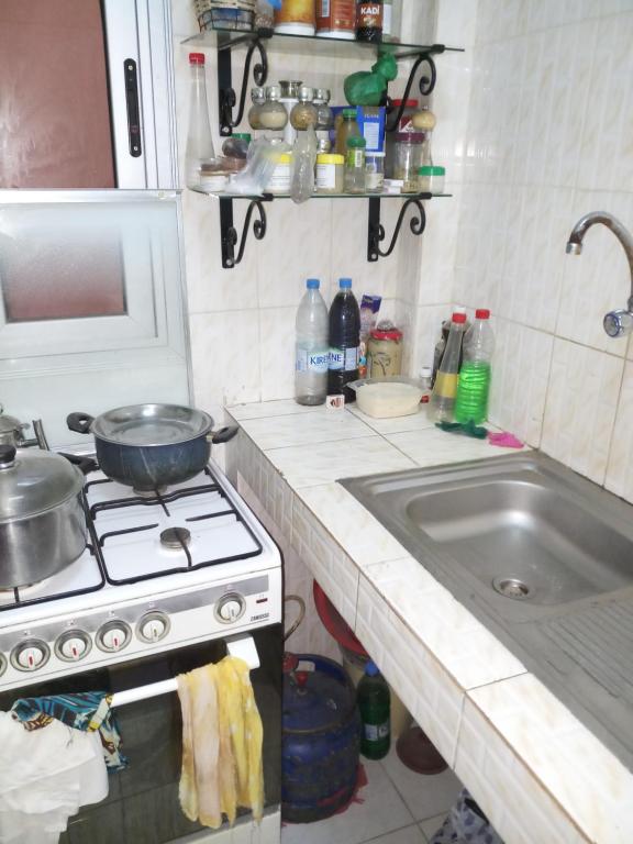 Il comprend une petite cuisine équipée d'une cuisinière et d'un évier. dans l'établissement KEUR AMINATA, à Dakar