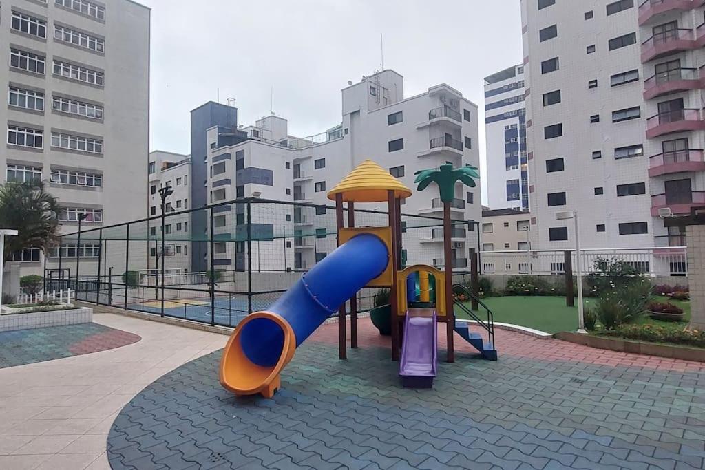 einen Spielplatz mit Rutsche in einer Stadt in der Unterkunft Apartamento a 50 metros da Praia para utilização da piscina precisa de Atestado Médico in Praia Grande