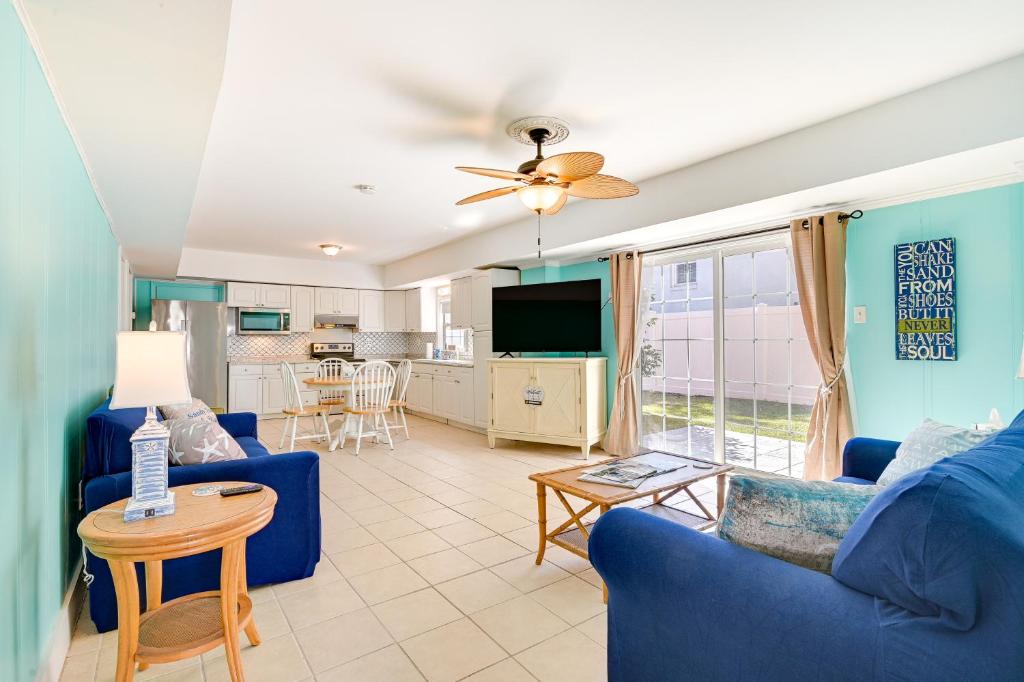 a living room with a blue couch and a table at Pawleys Island Retreat - Golf Cart Included! in Pawleys Island