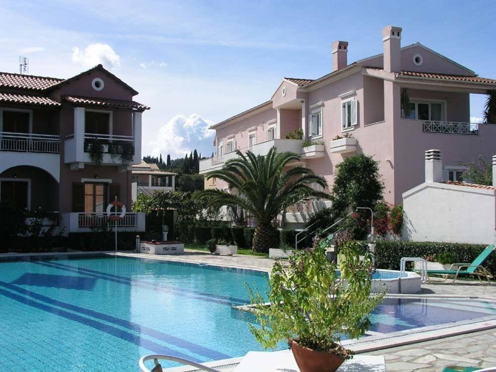 a villa with a swimming pool in front of a house at Angela Corfu in Corfu Town