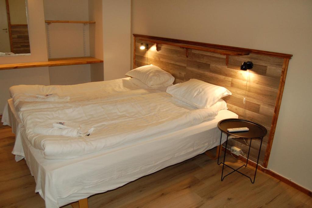 a large white bed in a room with a chair at Golden Spa Hotell in Eskilstuna