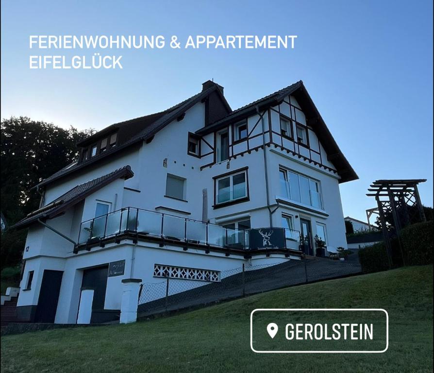 a white house with the words fremontivating and apartmentlez at Ferienwohnung Eifelglück in Pelm