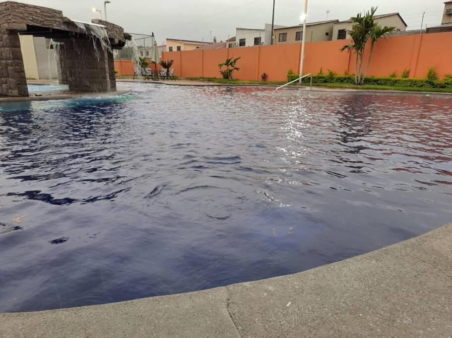 une piscine d'eau en face d'un bâtiment dans l'établissement Linda Suite minimalista, à Guayaquil