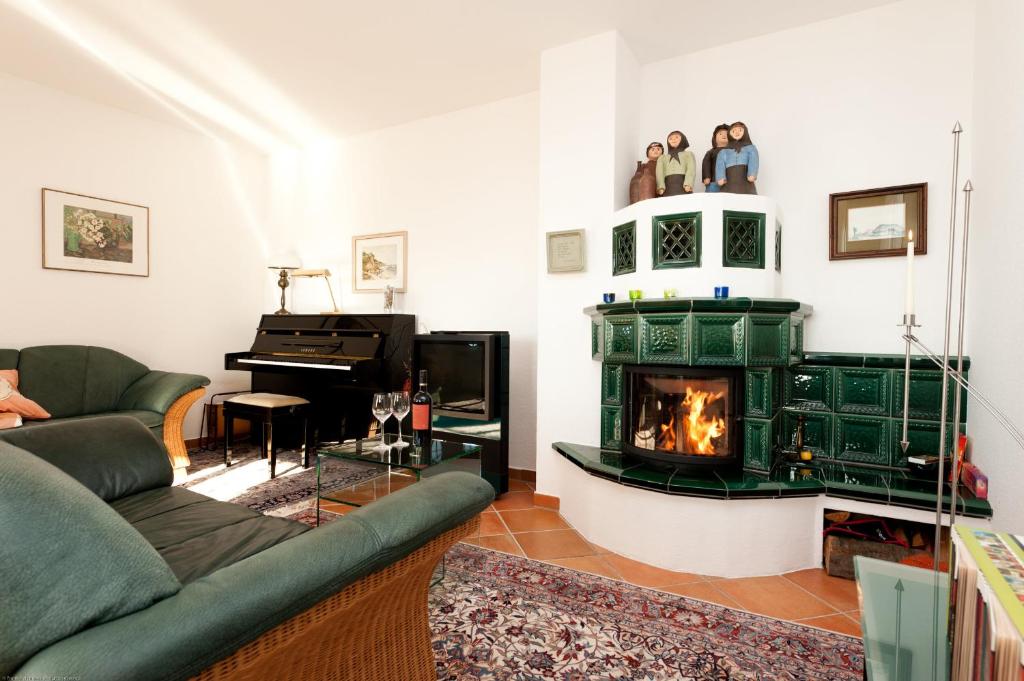 uma sala de estar com lareira e piano em Villa Düne mit großer Sonnenterrasse, Kamin, Wlan und Tiefgarage für 2-4 Personen em Kühlungsborn