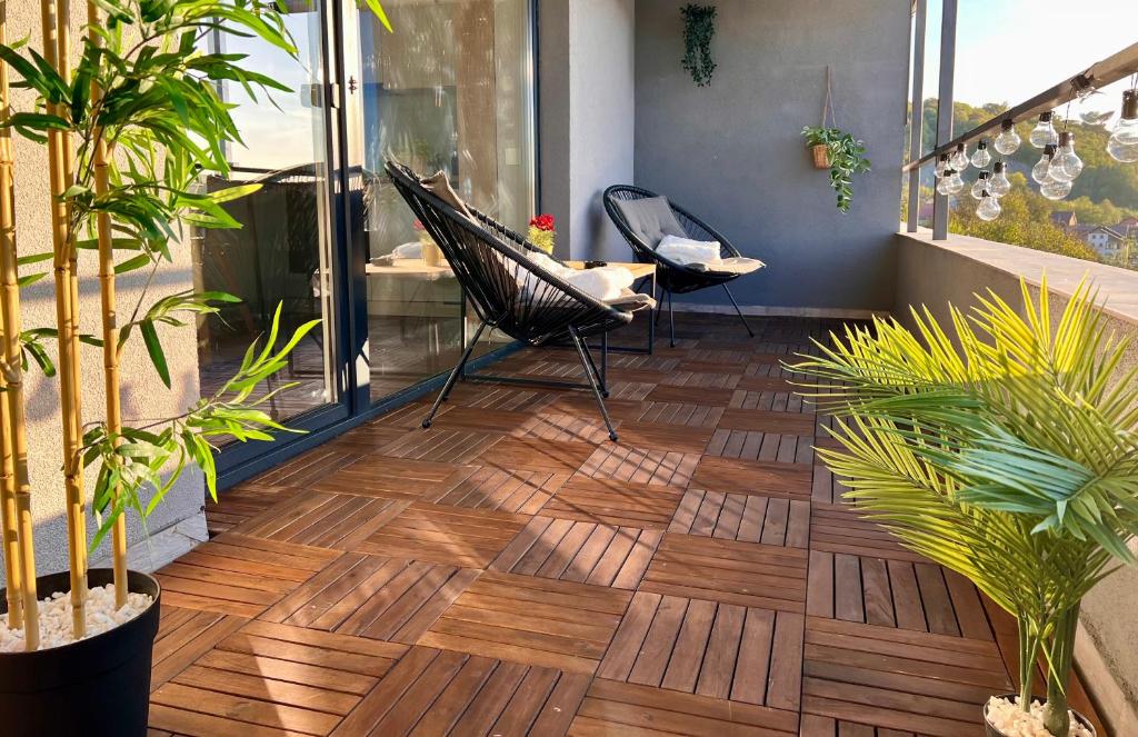 a patio with a wooden floor with chairs and plants at Ghinda Nest in Bistriţa