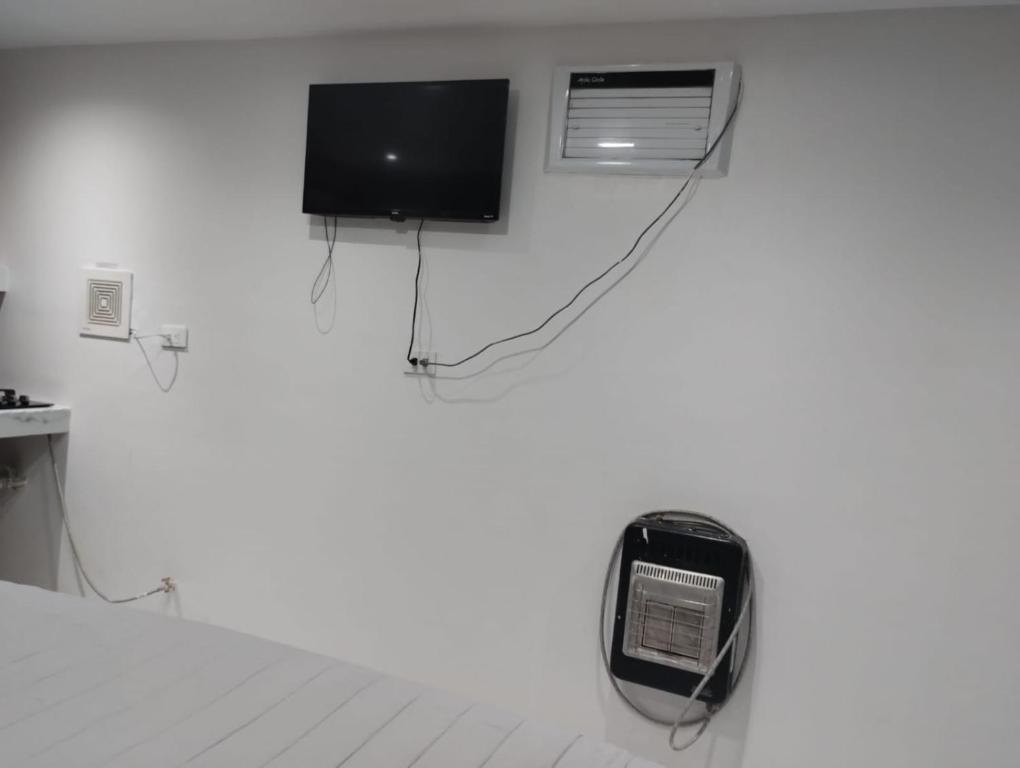 um quarto com uma televisão e um telefone na parede em HABITACION SENCILLA CAMA KS Y BAÑO em Ciudad Juárez