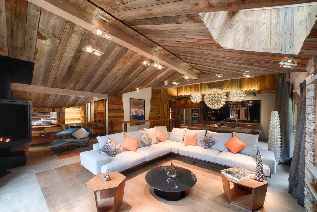 ein Wohnzimmer mit einem Sofa und einem TV in der Unterkunft Luxueux Penthouse avec SPA privé - Cap Crystal Lodge in Tignes