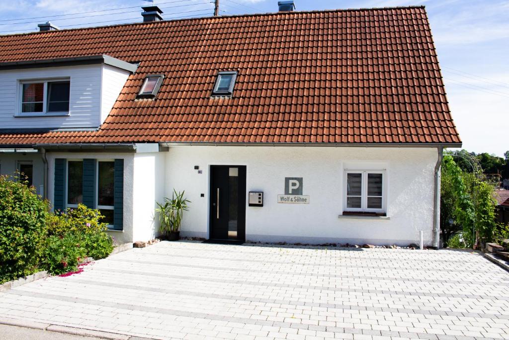 una casa bianca con il tetto rosso di Ferienwohnung Wolf a Veringenstadt