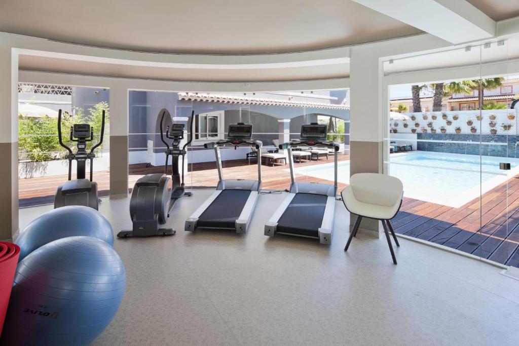 a gym with exercise equipment and a swimming pool at Costa d'Oiro Ambiance Village in Lagos
