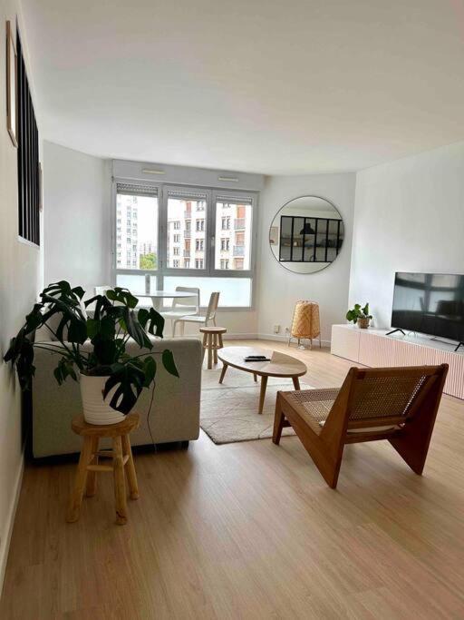 uma sala de estar com um sofá e uma mesa em Jolie cosy appartement de 52m2 em Asnières-sur-Seine