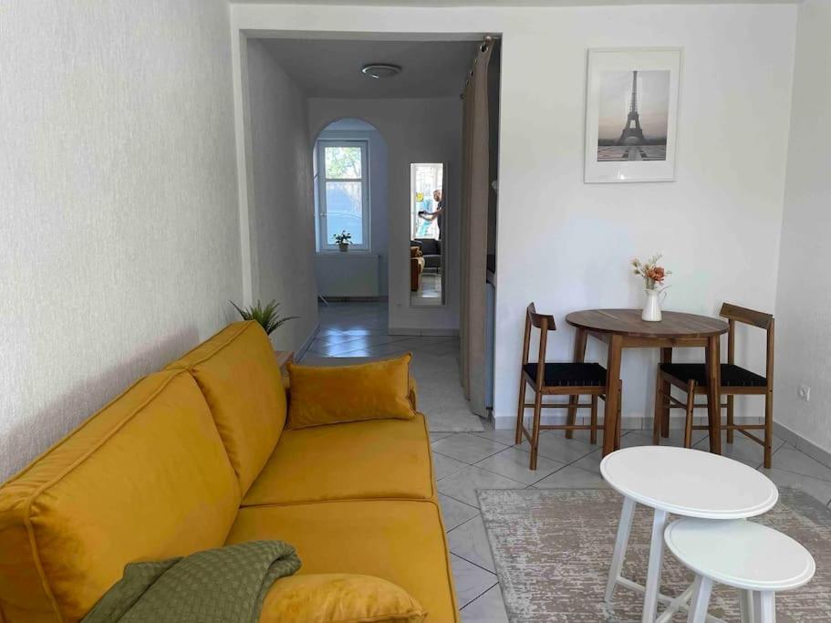 a living room with a yellow couch and a table at Cocooning in Colmar