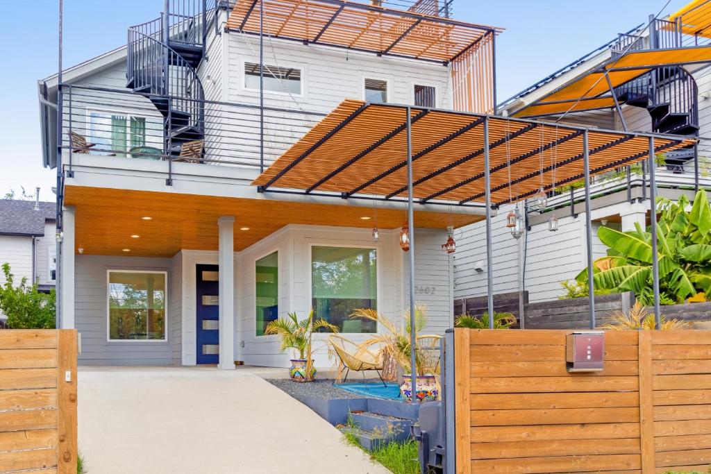 a house with a wooden fence in front of it at EastSide Rooftop Oasis in Austin