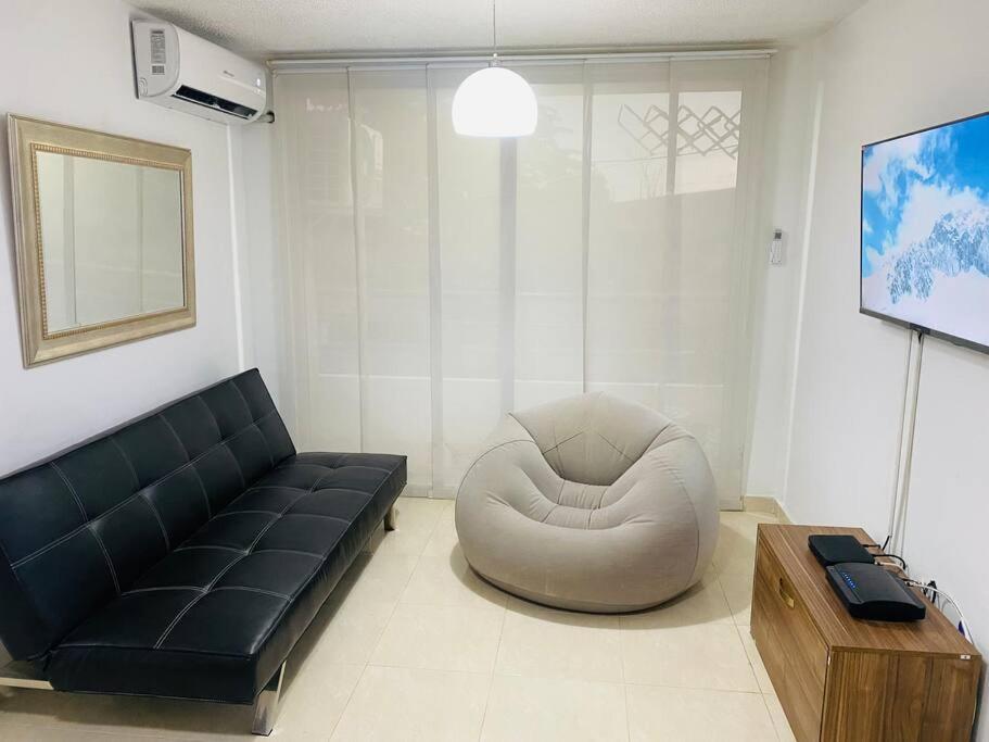 een woonkamer met een bank en een stoel bij Hermoso lugar para descansar in Barranquilla