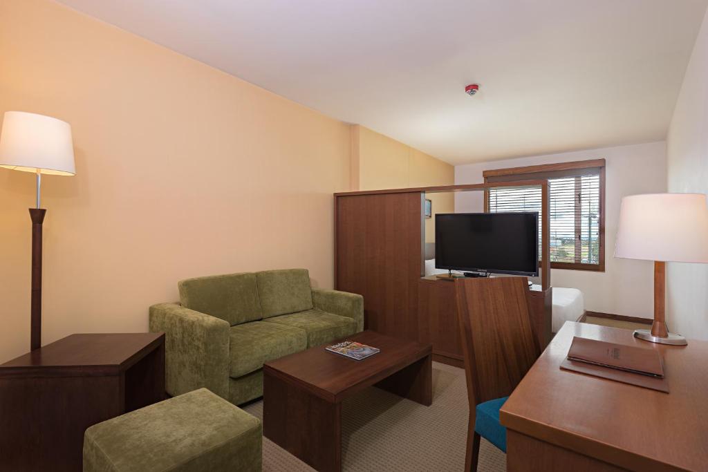 a hotel room with a chair and a television at Hotel Habitel Select in Bogotá