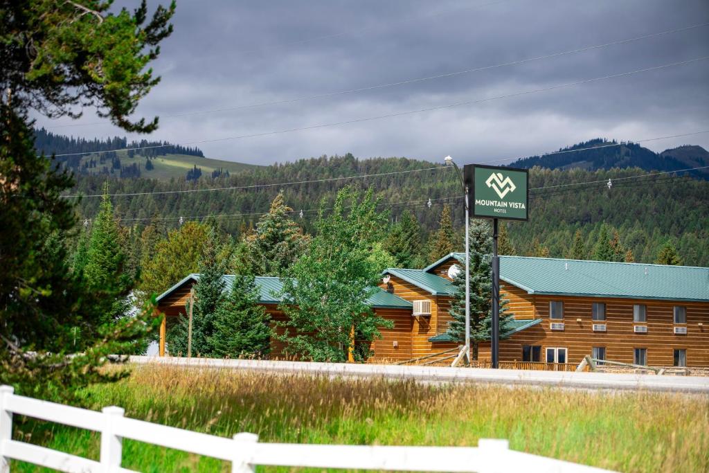 un cartello di fronte a una baita di tronchi di Mountain Vista Hotel a West Yellowstone