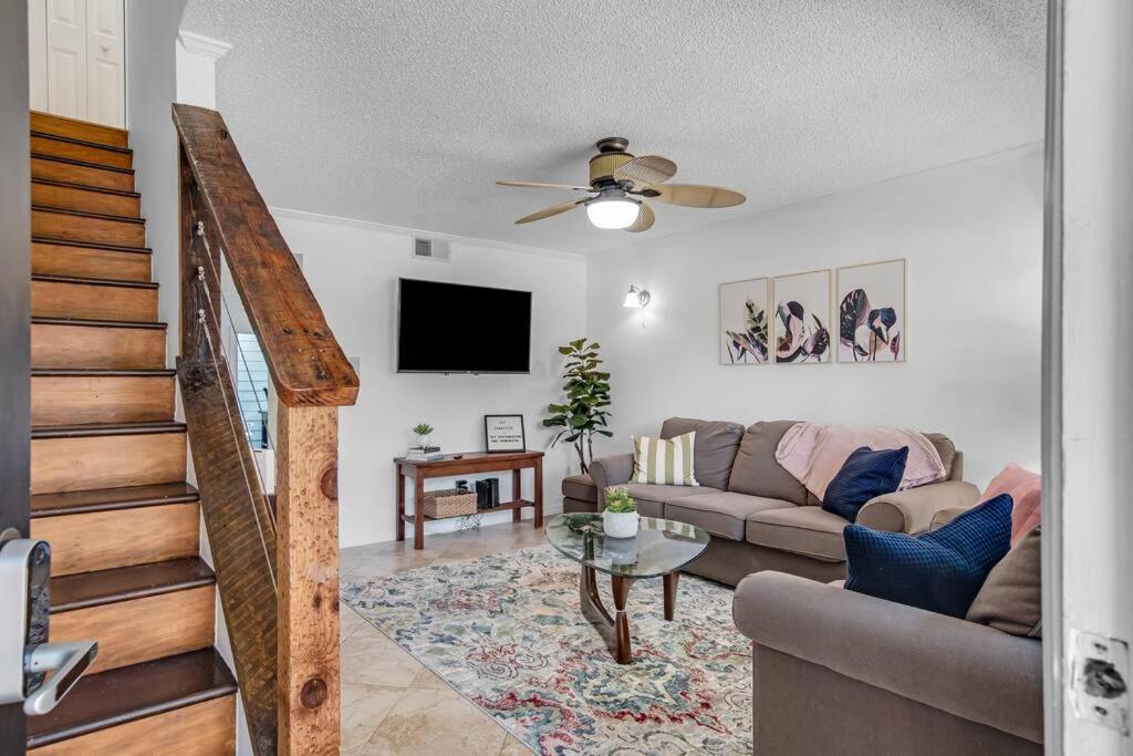 uma sala de estar com um sofá e uma televisão em Beachside Duplex off Flagler with FREE garage parking em New Smyrna Beach