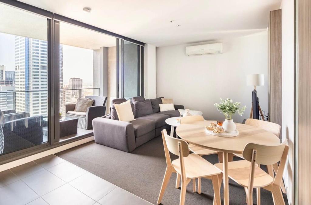 ein Wohnzimmer mit einem Tisch und einem Sofa in der Unterkunft Spacious Apartment in the CBD in Melbourne