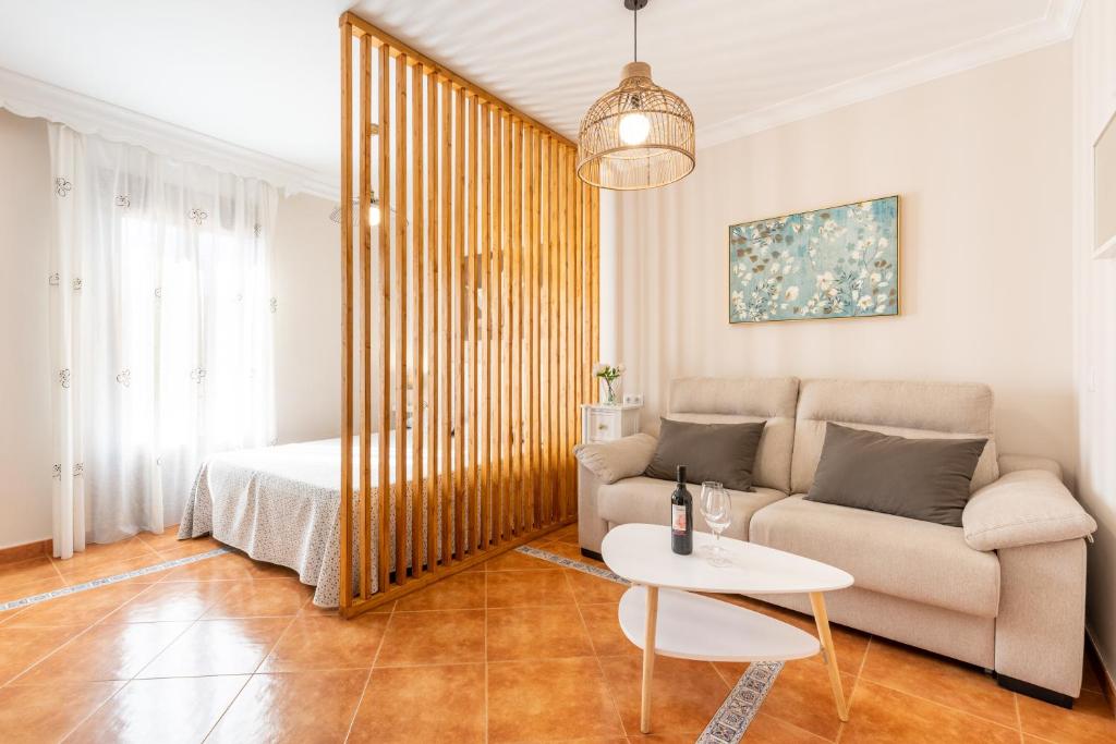 sala de estar con sofá y mesa en CASA ANGELITA Caminito del Rey, Apartamento con cocina en el centro de Andalucía, en Valle de Abdalajís
